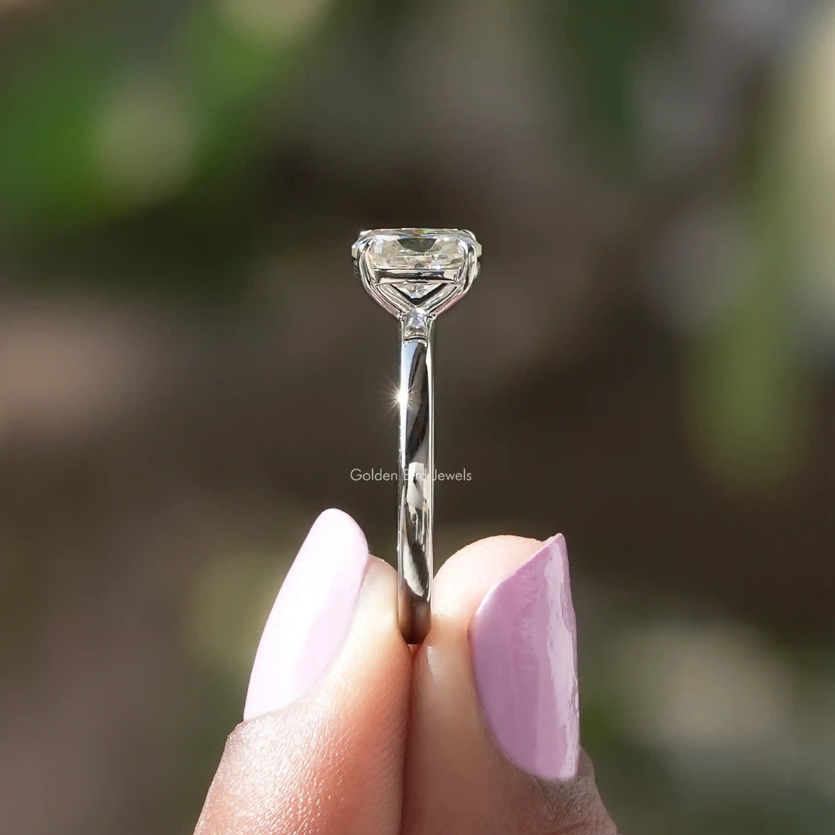 Side View of Cushion Cut Moissanite Ring In two fingers