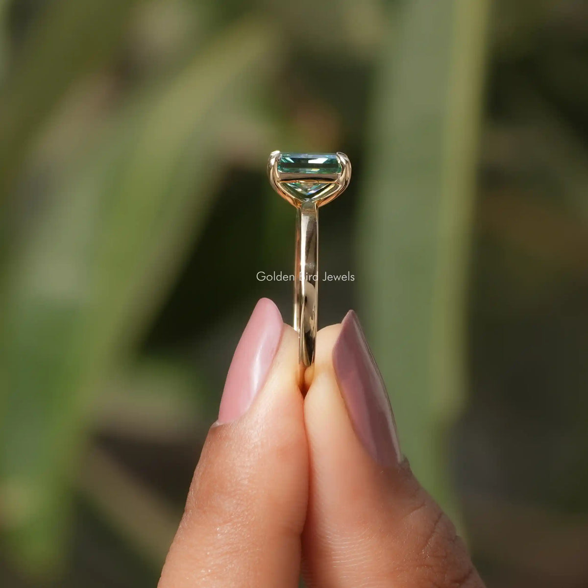 Side View of Radiant Cut Solitaire Engagement Ring In two fingers