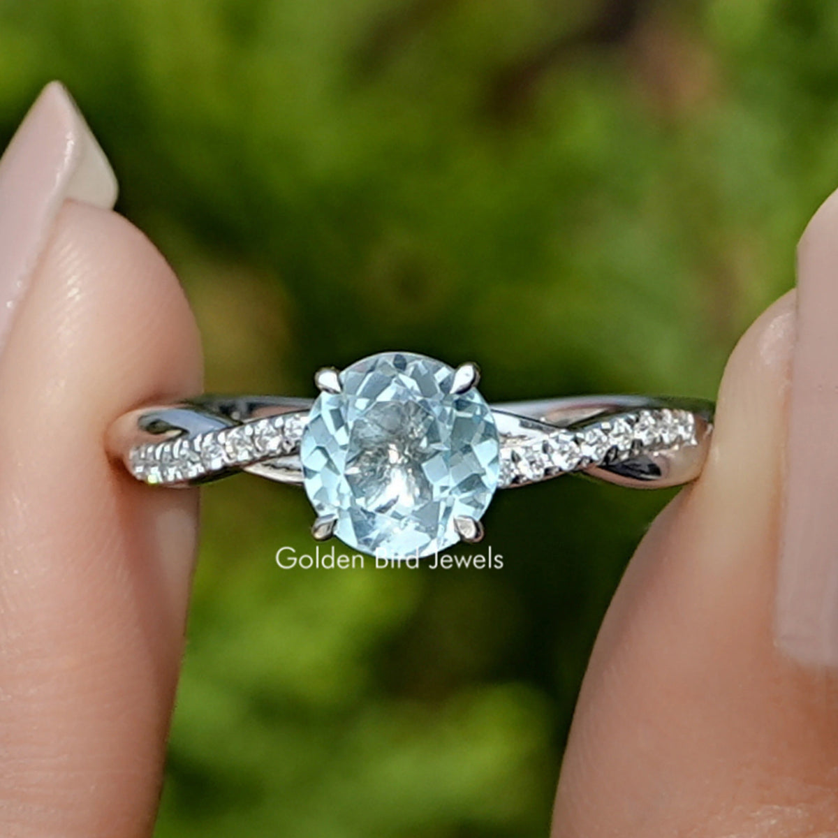 Front view of Round Cut Gemstone Ring in two fingers