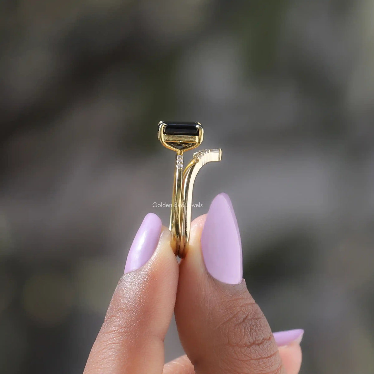 Side View of Emerald Cut Moissanite Bridal Ring In two fingers