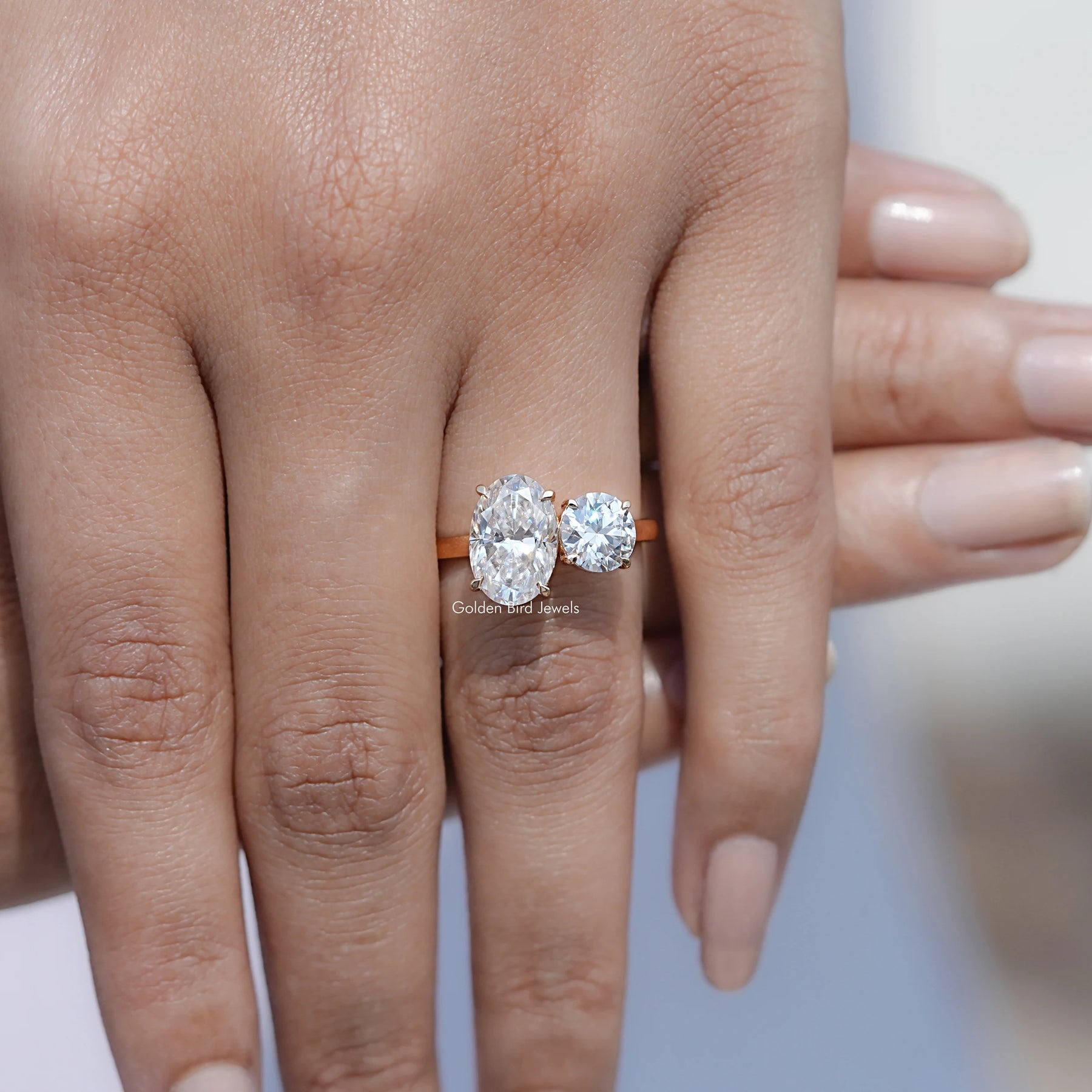 In front finger View Of Oval And Round Cut Moissanite Toi Et Moi Ring