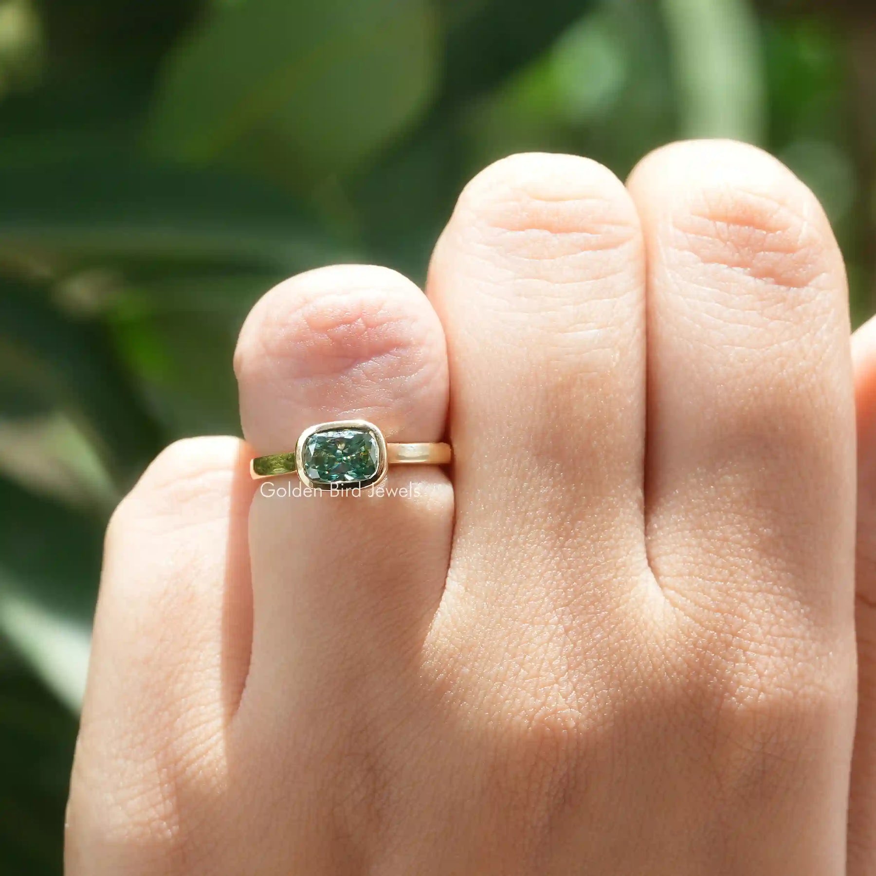 Front View of Green Elongated Cushion Moissanite Engagement Ring In Finger