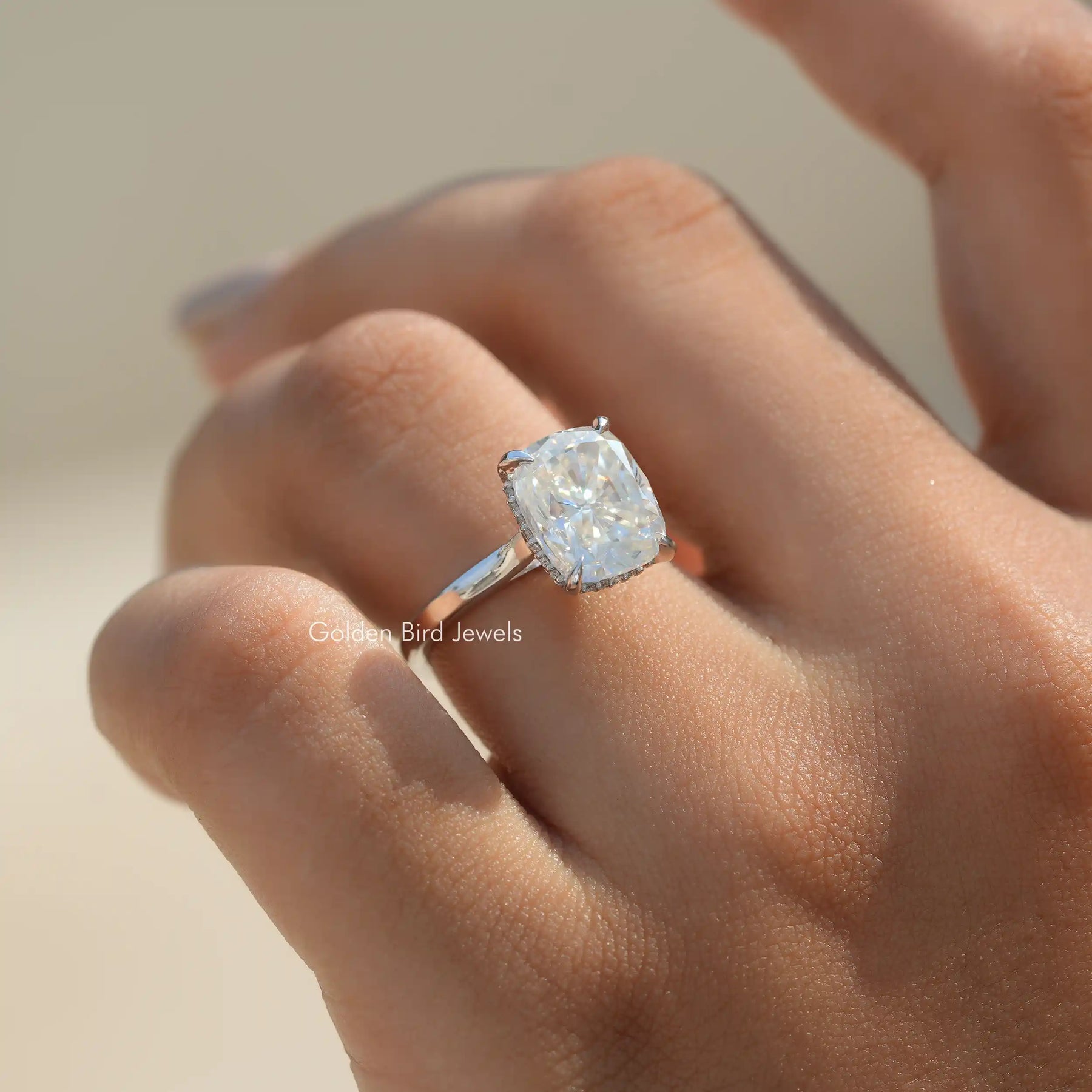 In finger front view of Elongated Cushion Hidden Halo Ring in unique shape