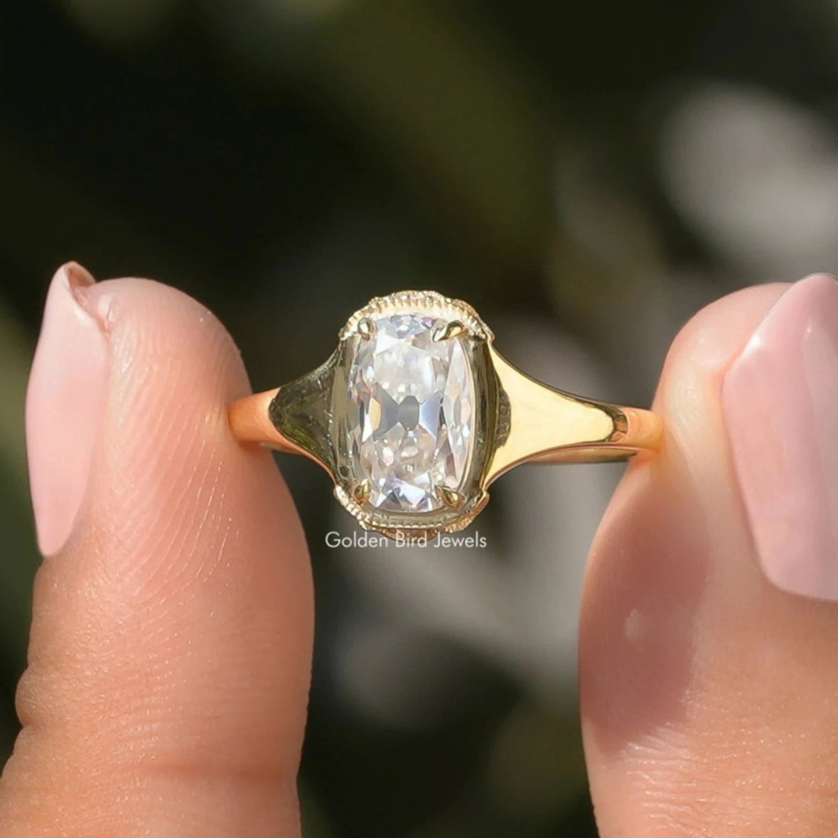 Two fingers holding the Elongated Old Mine Cushion Cut Moissanite Ring