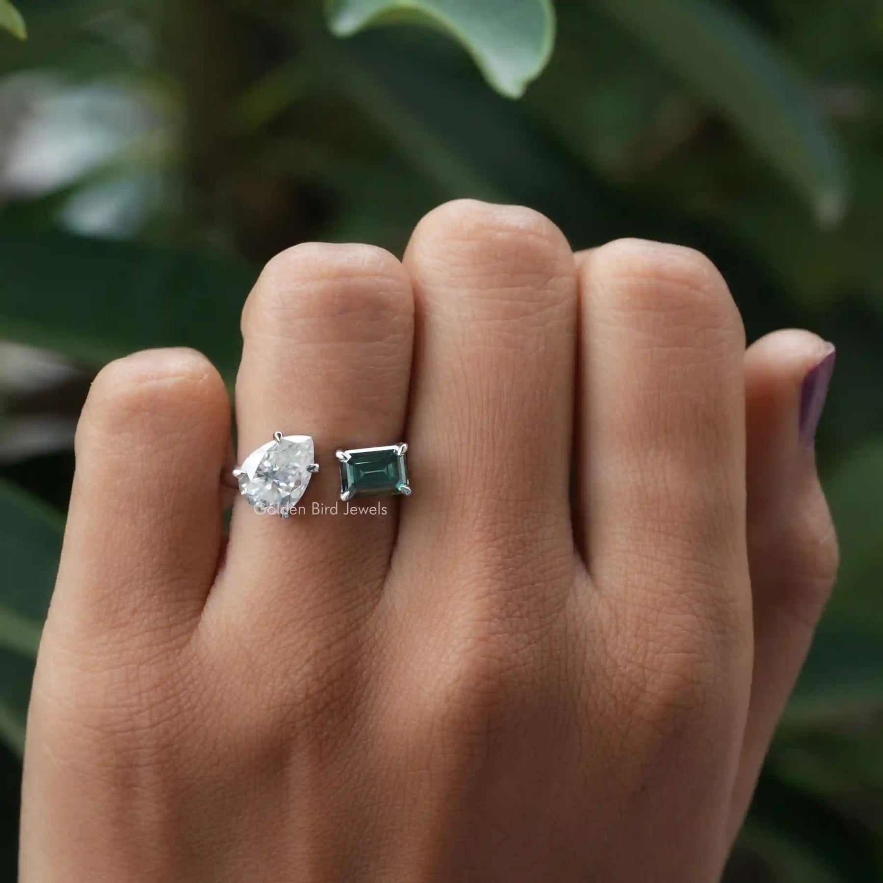 Emerald and pear-cut moissanite  ring in a secure setting