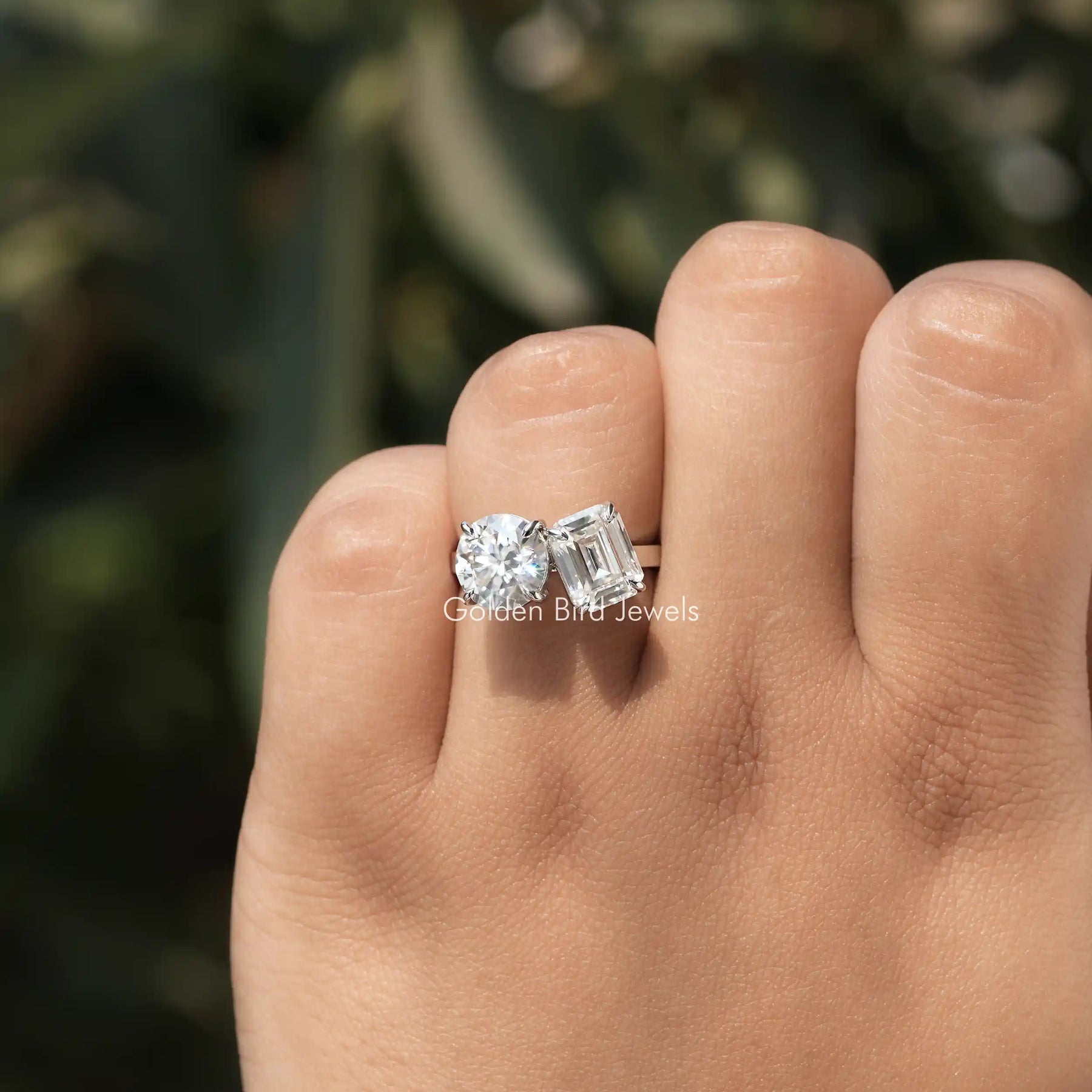 View of Emerald And Round Cut Moissanite Toi Et Moi Ring In Finger