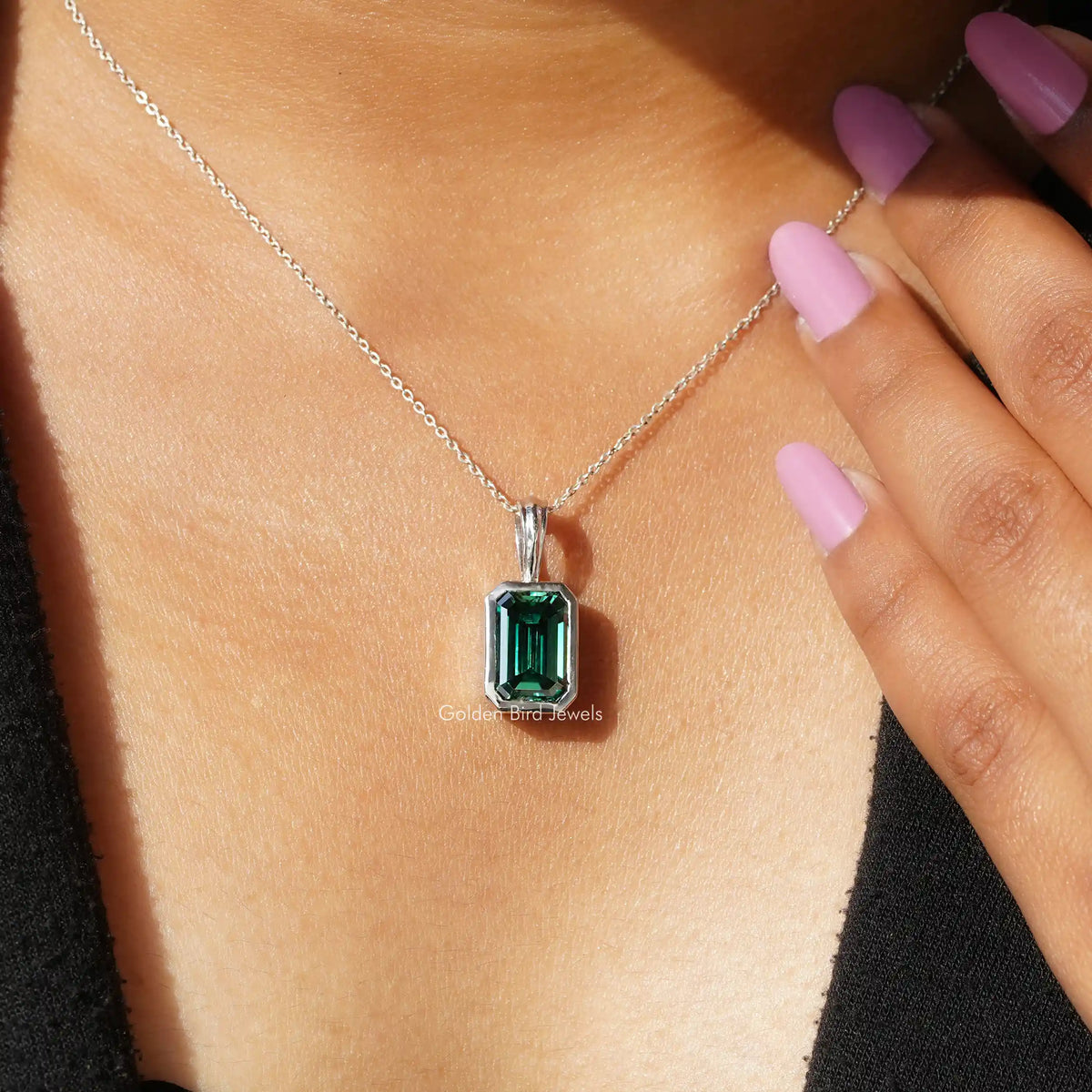 In neck view of emerald cut moissanite halo pendant