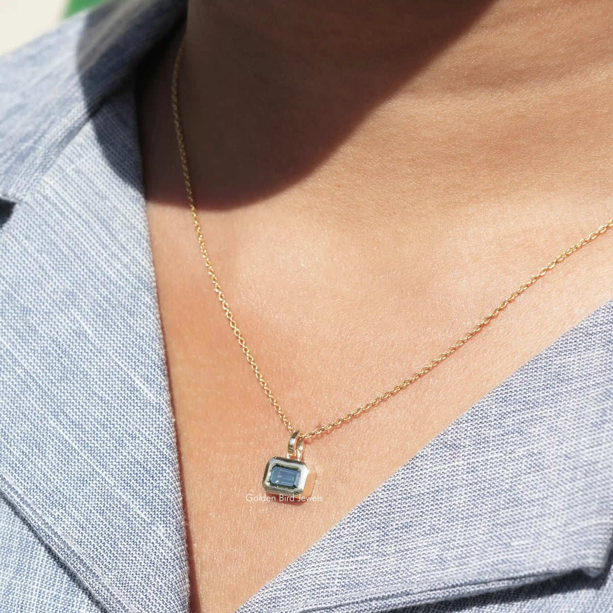 In neck view of emerald cut moissanite halo pendant
