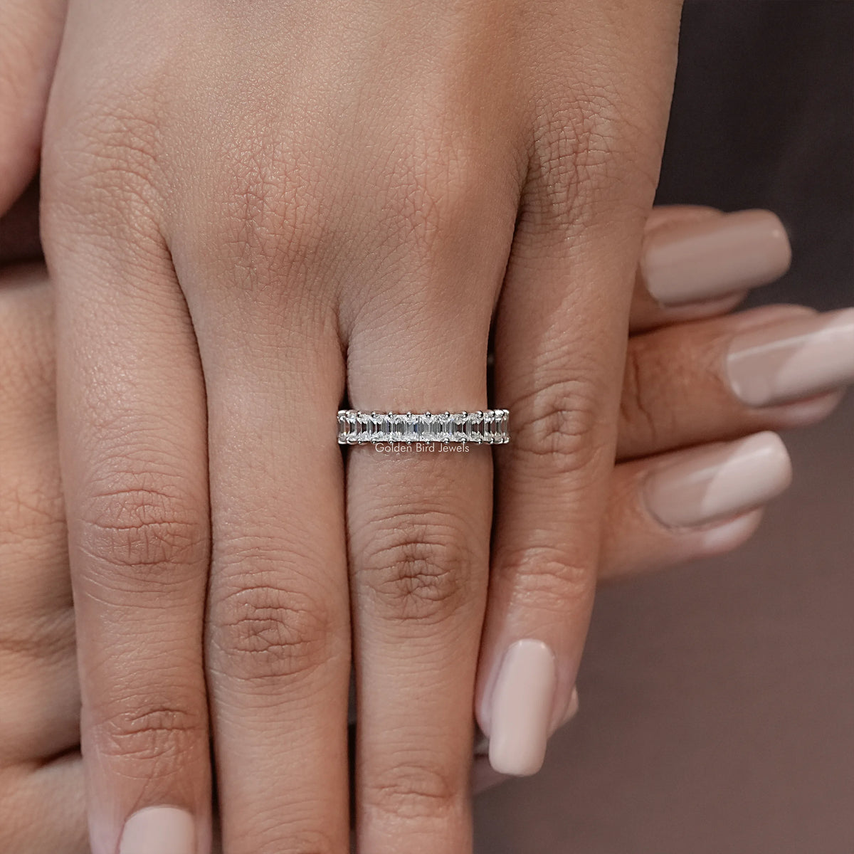 Silver half-eternity ring with baguette-cut stones, centered on the finger