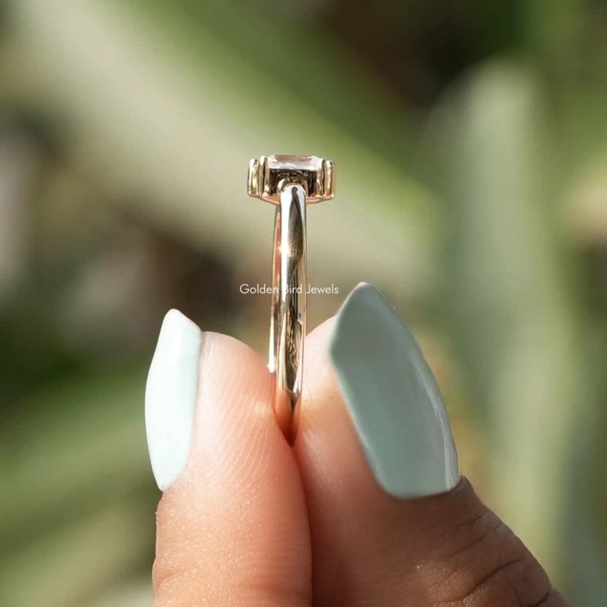 Side view of moissanite  ring holding on two fingers
