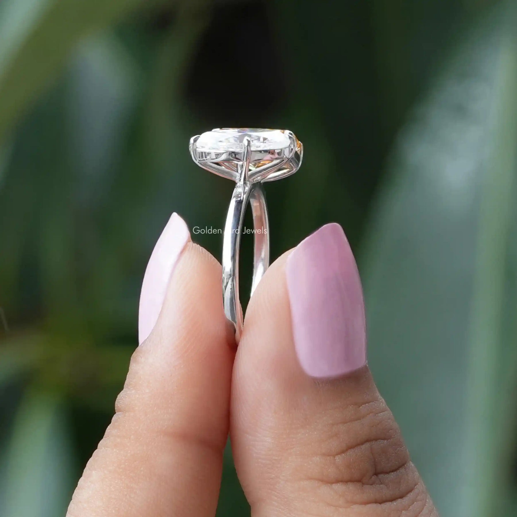Side View of Marquise And Radiant Cut Moissanite Ring In two fingers