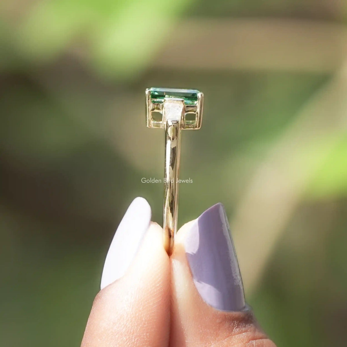 Side View of Green Emerald Cut Moissanite Ring In two fingers