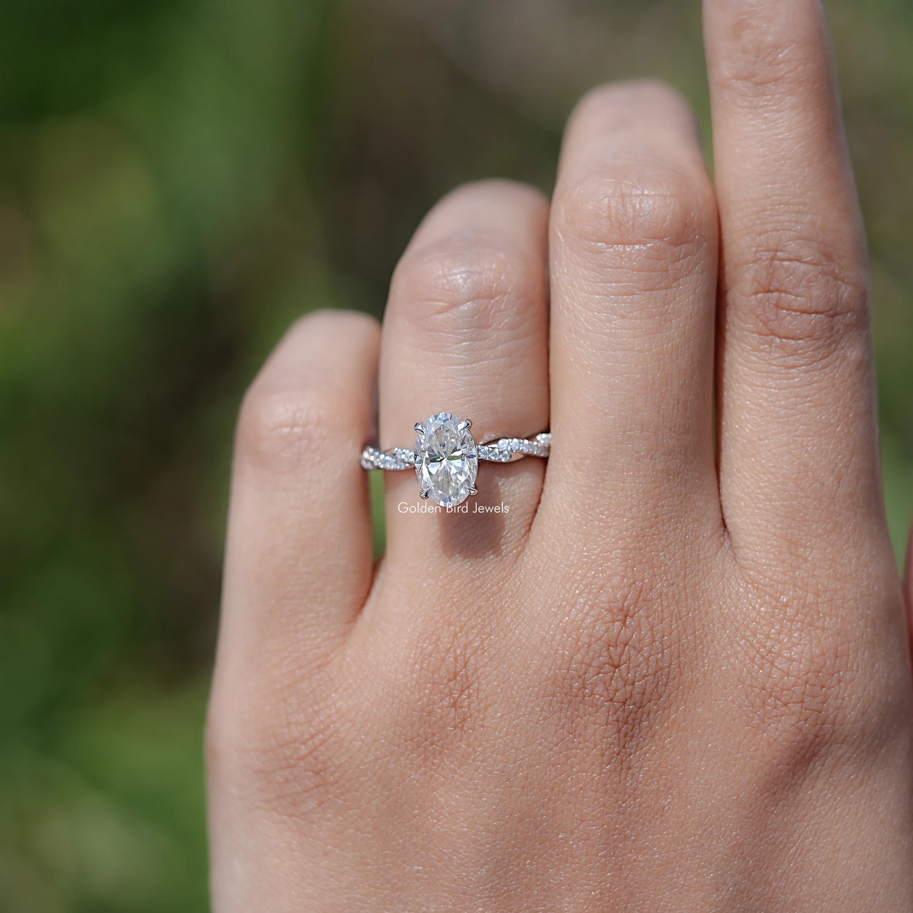 In finger view of Oval Shaped Moissanite Twisted Shank Accent Ring