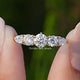 Pear And Round Cut Lab Diamond Five Stone Ring Between Fingers