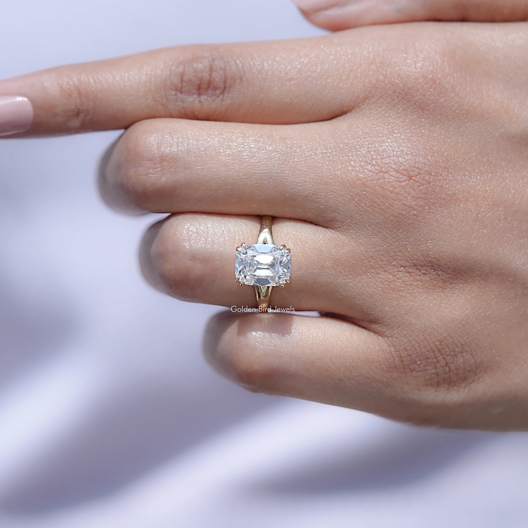 In finger front view of Old Mine Cushion Cut ring in unique shape