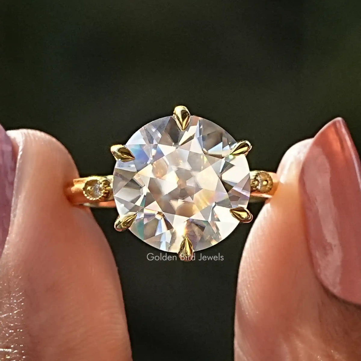 Two fingers holding the Old European Round Cut Moissanite Engagement Ring