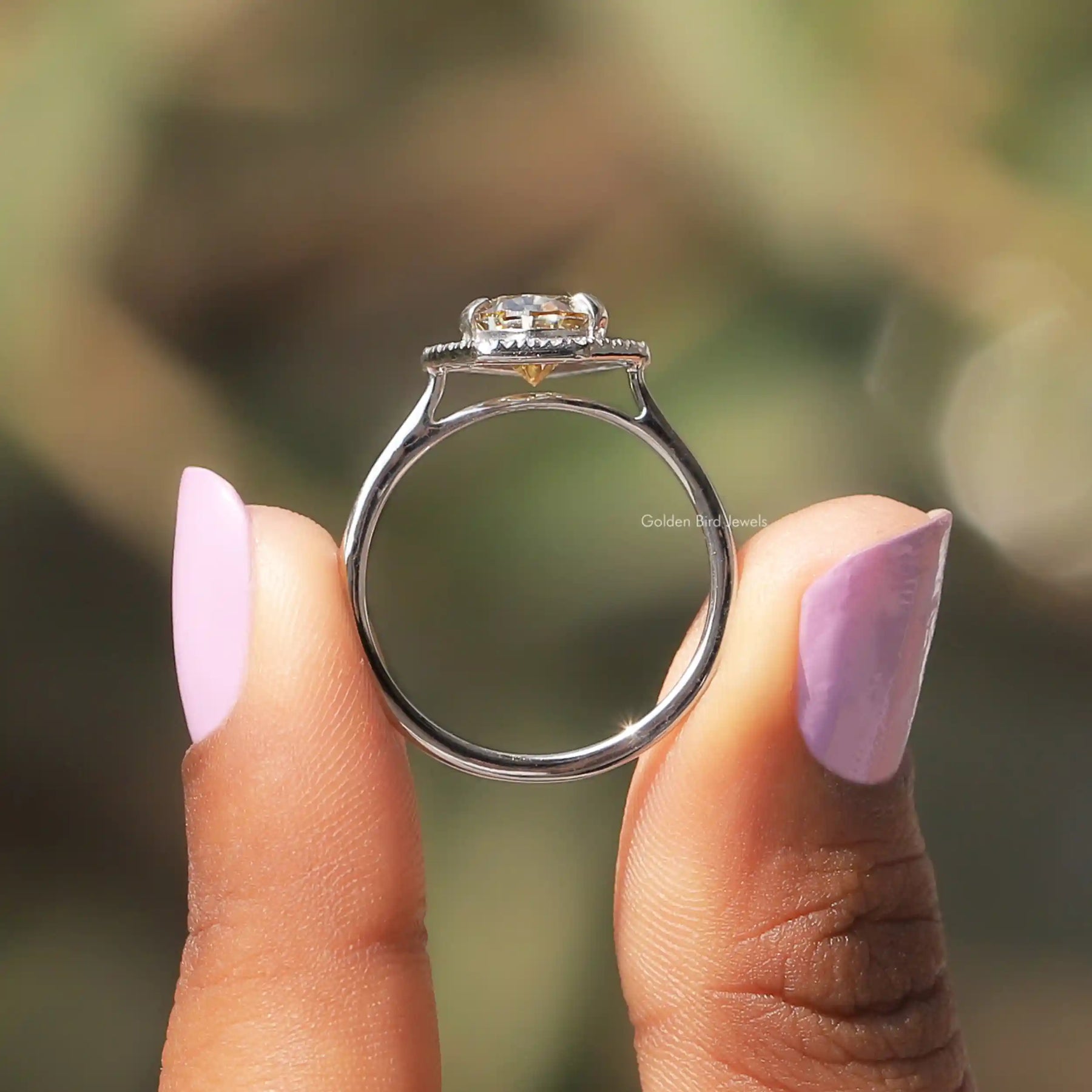 Back View of Pear Moissanite Halo Engagement Ring In two fingers