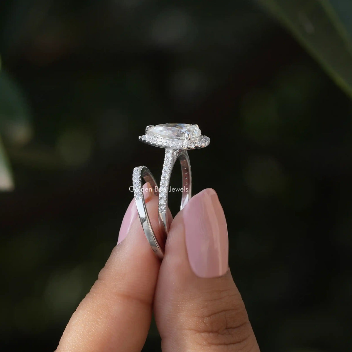 SIde view of a moissanite ring set in holding two fingers