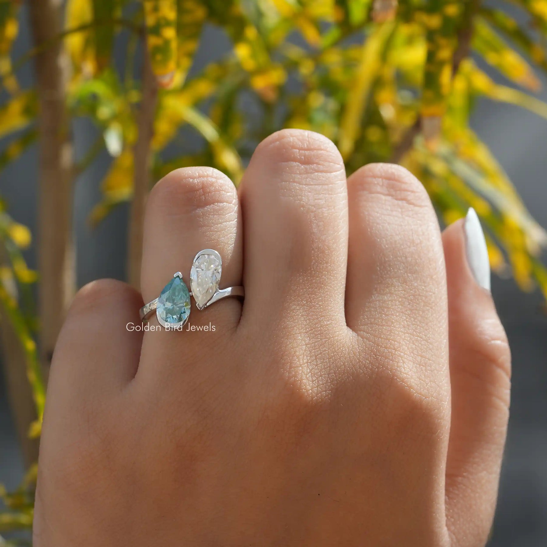 Finger view of a pear cut moissanite  engagement ring