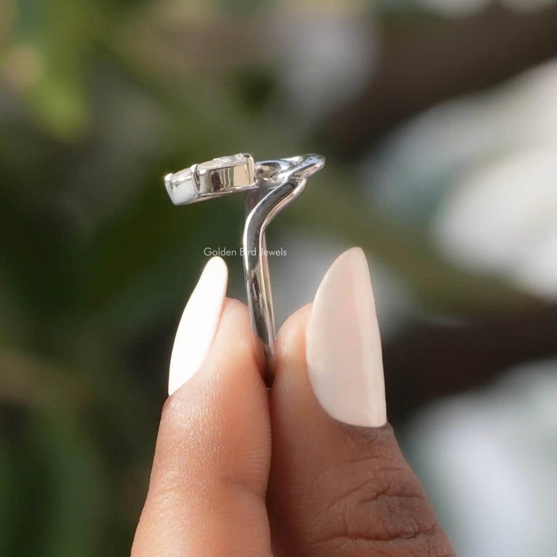 Side View of Pear Moissanite Vintage Style Toi Moi Ring In two fingers