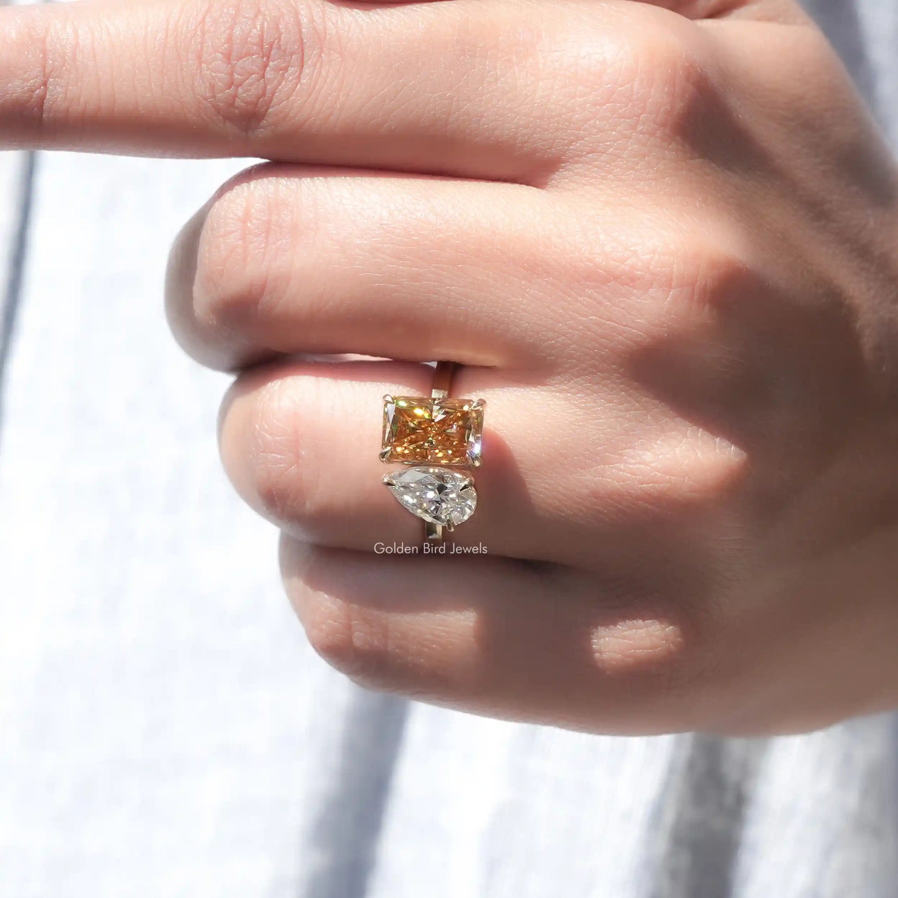 Finger view of Fancy Colored Pear And Radiant Cut Two Stone Ring