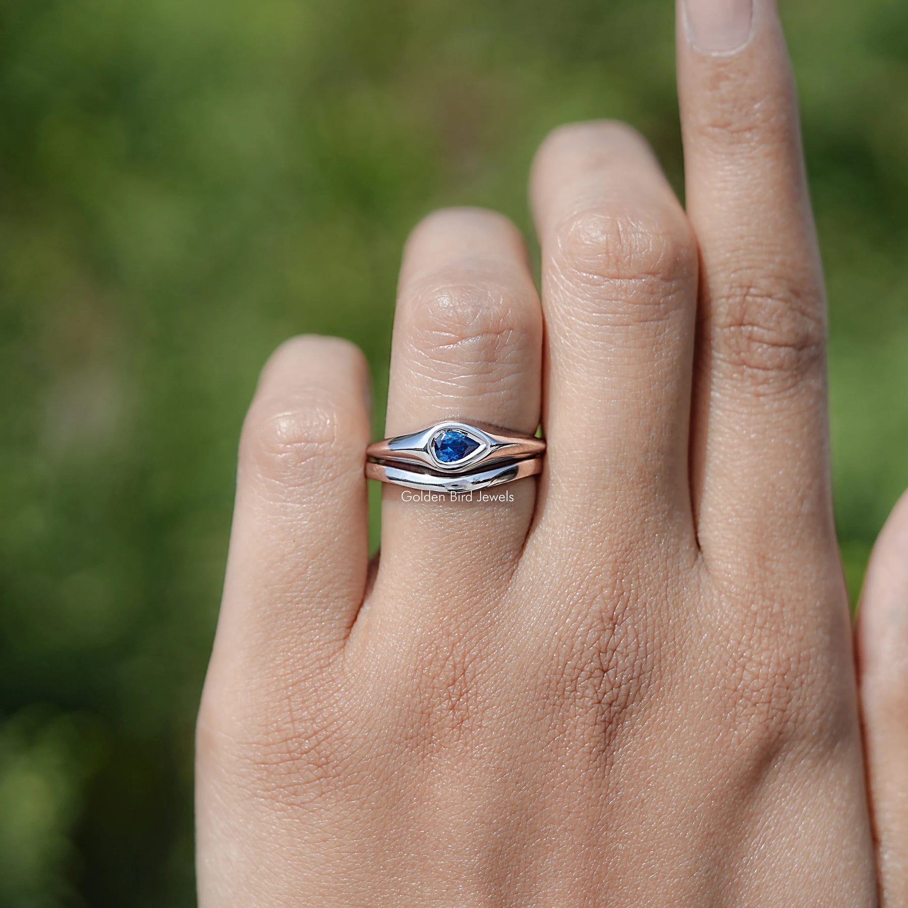 In finger view of Pear Shaped Solitaire Moissanite Ring