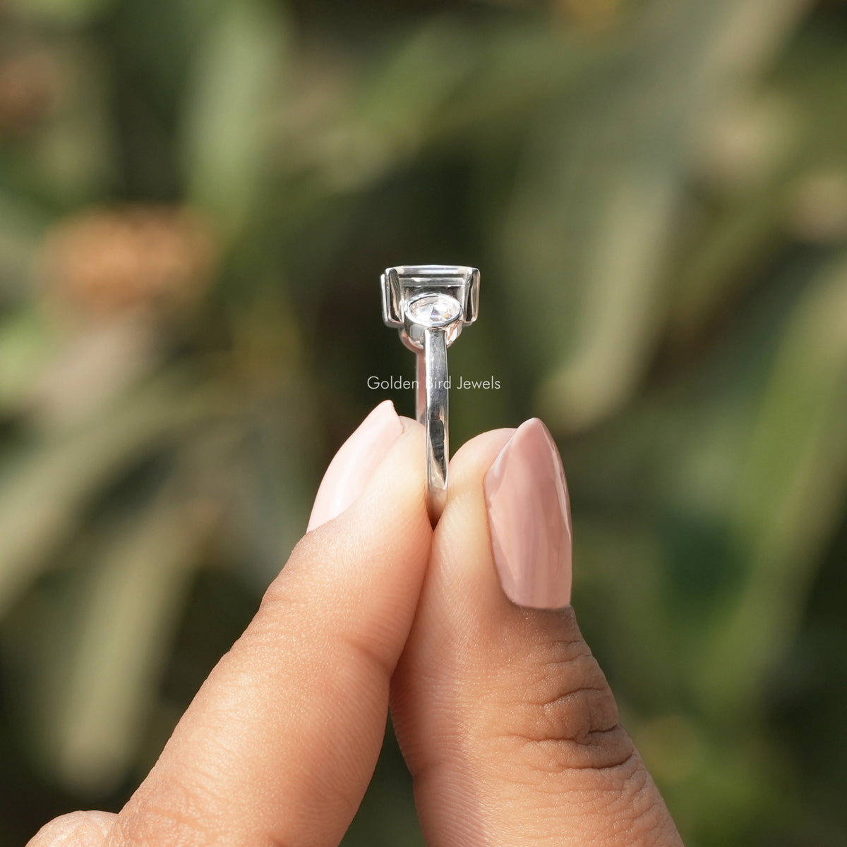 Side View of Portrait Cut Princess Three Stone Ring In two fingers