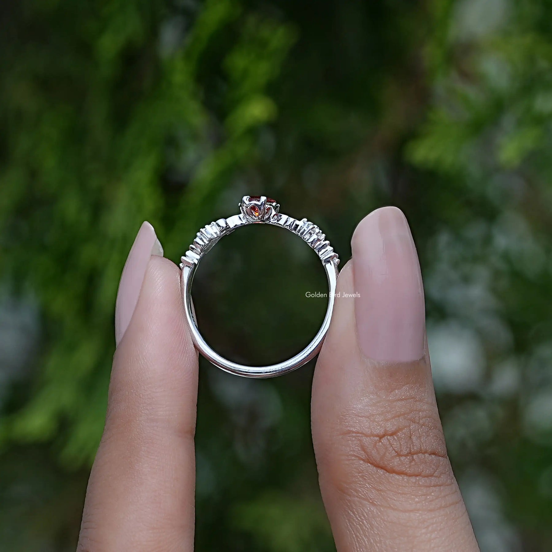 Back View of Oval Cut Accent Stone Stone Engagement Ring In two fingers