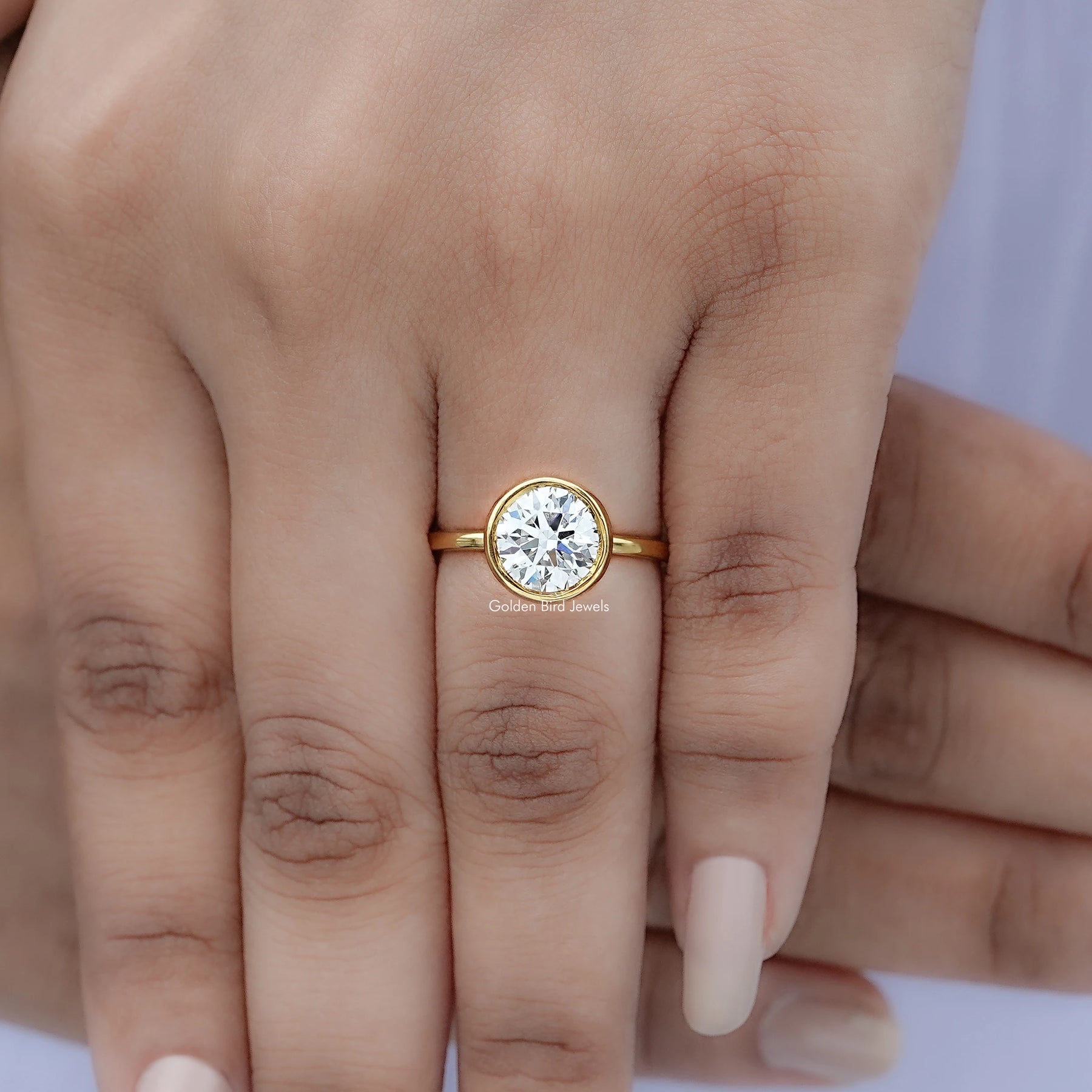 Top view of Round Diamond Bezel Set Ring Held In Finger