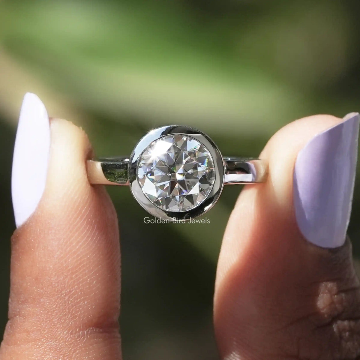 Front View of Round Cut Moissanite Engagement Bezel Set Ring In two Fingers