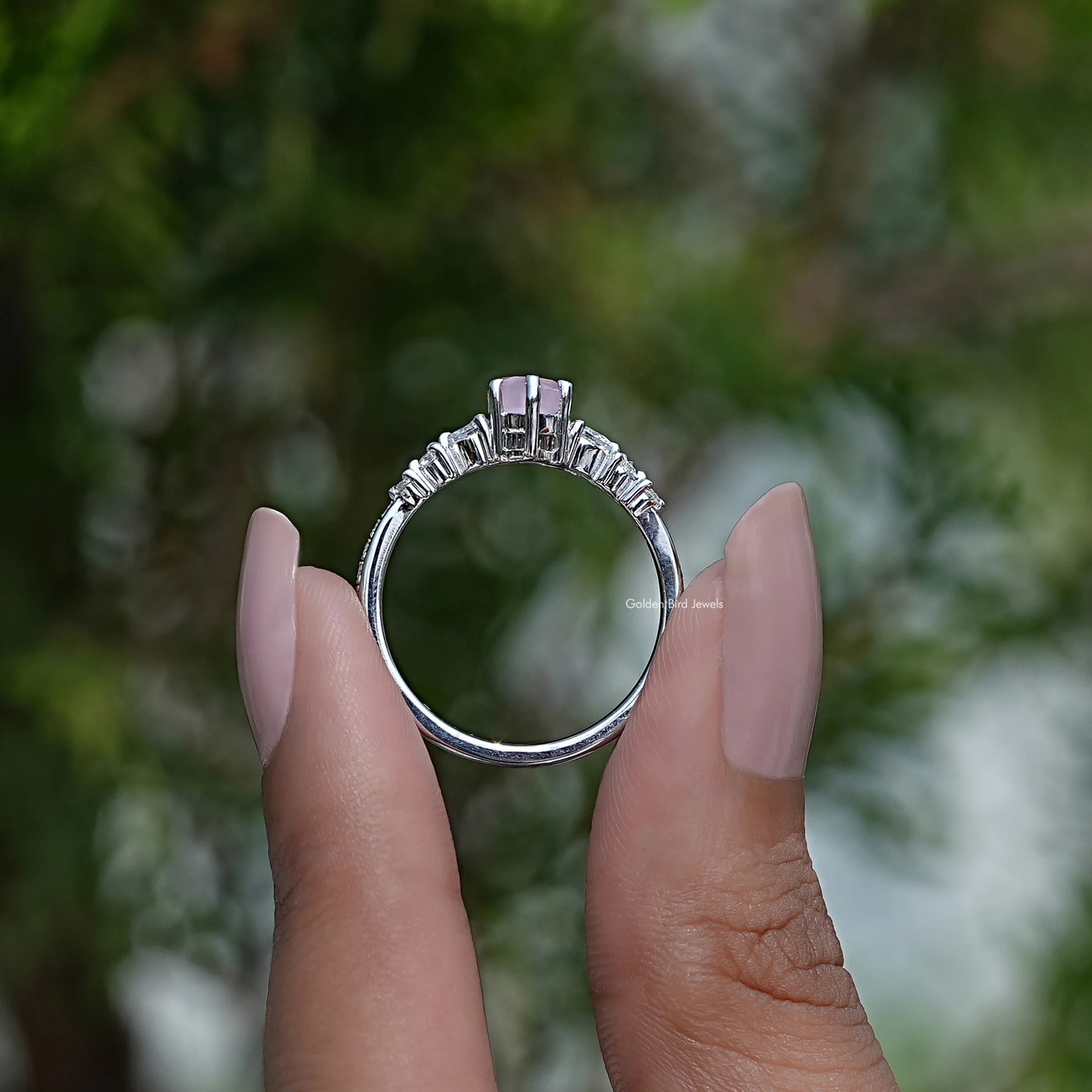 Back View of Emerald Cut Blue Topaz Gemstone Halo Ring in two fingers