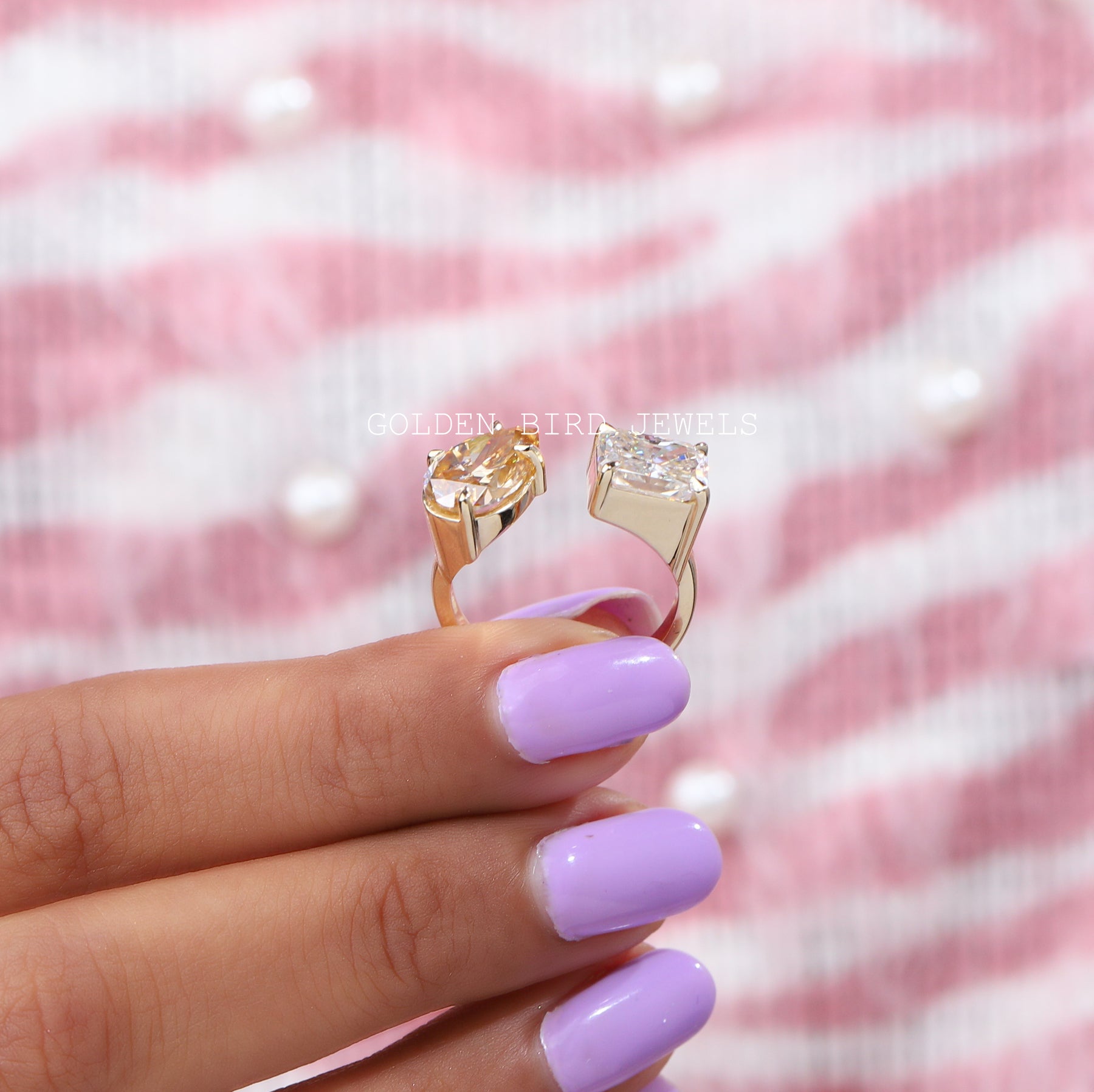 Back view of colorless radiant & yellow pear moissanite ring holding on two fingers