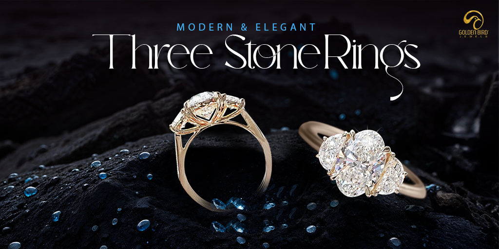 Three-stone engagement ring made by goldenbird jewels placed on black surface with glittering blue dew drops and text written"Elegamt and Modern- Three-stone engagement ring