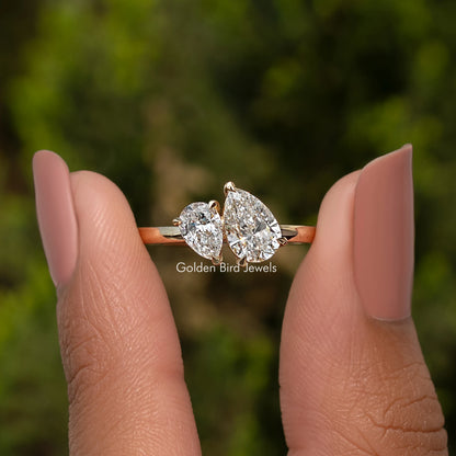 Pear Shaped Lab Diamond Two Stone Ring Held Between Fingers