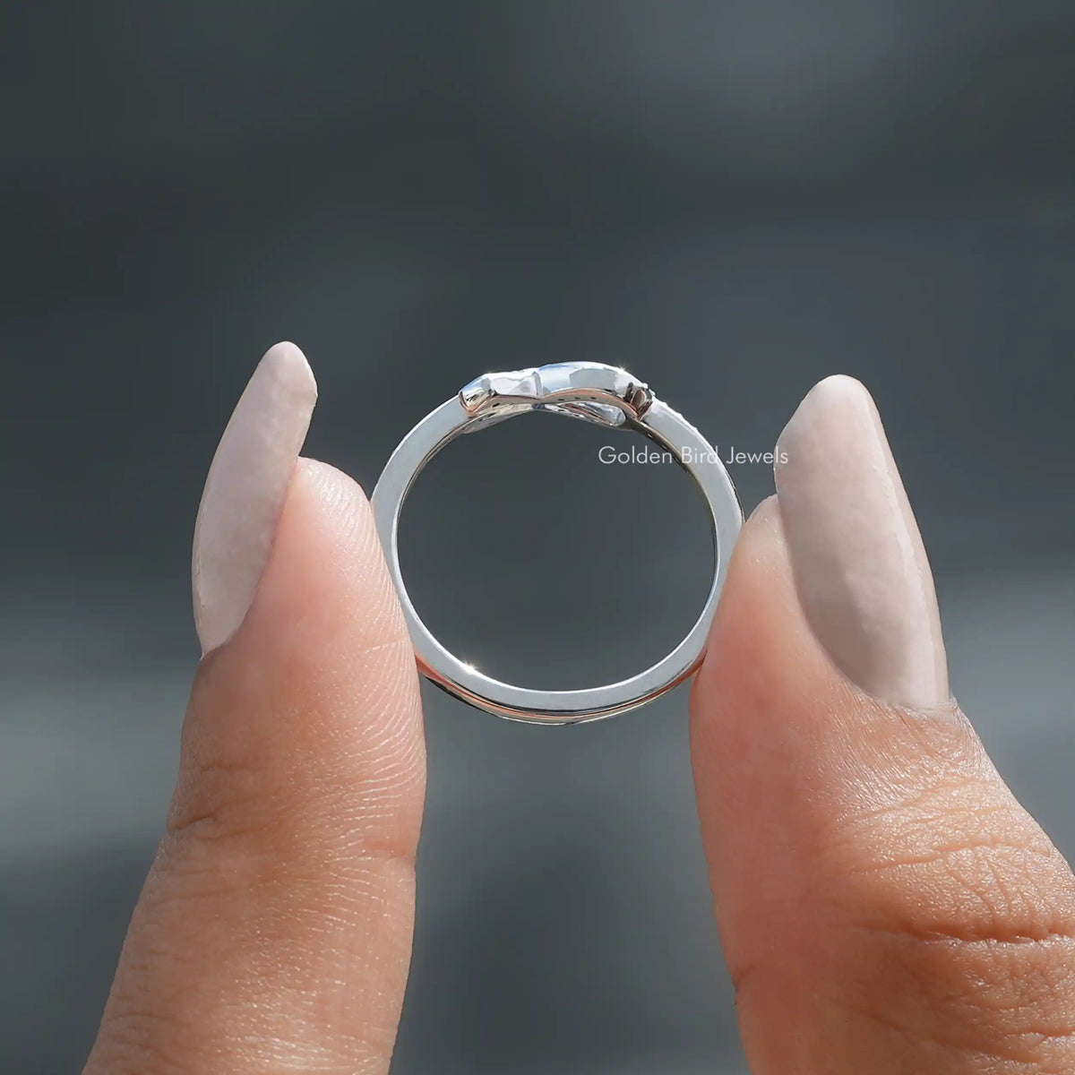 Back View of Ribbon Round Cut White Gold Ring in two fingers