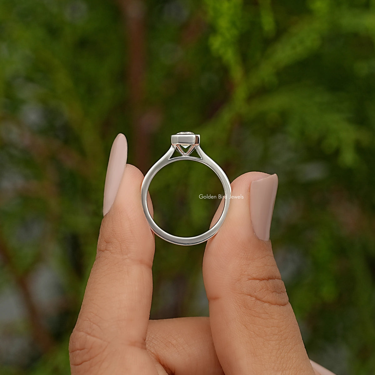 Emerald-cut moissanite bezel-set ring, top view showing square bezel setting