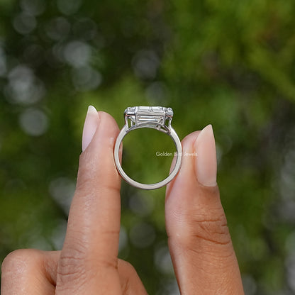 Side view of a sterling silver solitaire ring showing the raised emerald-cut stone setting