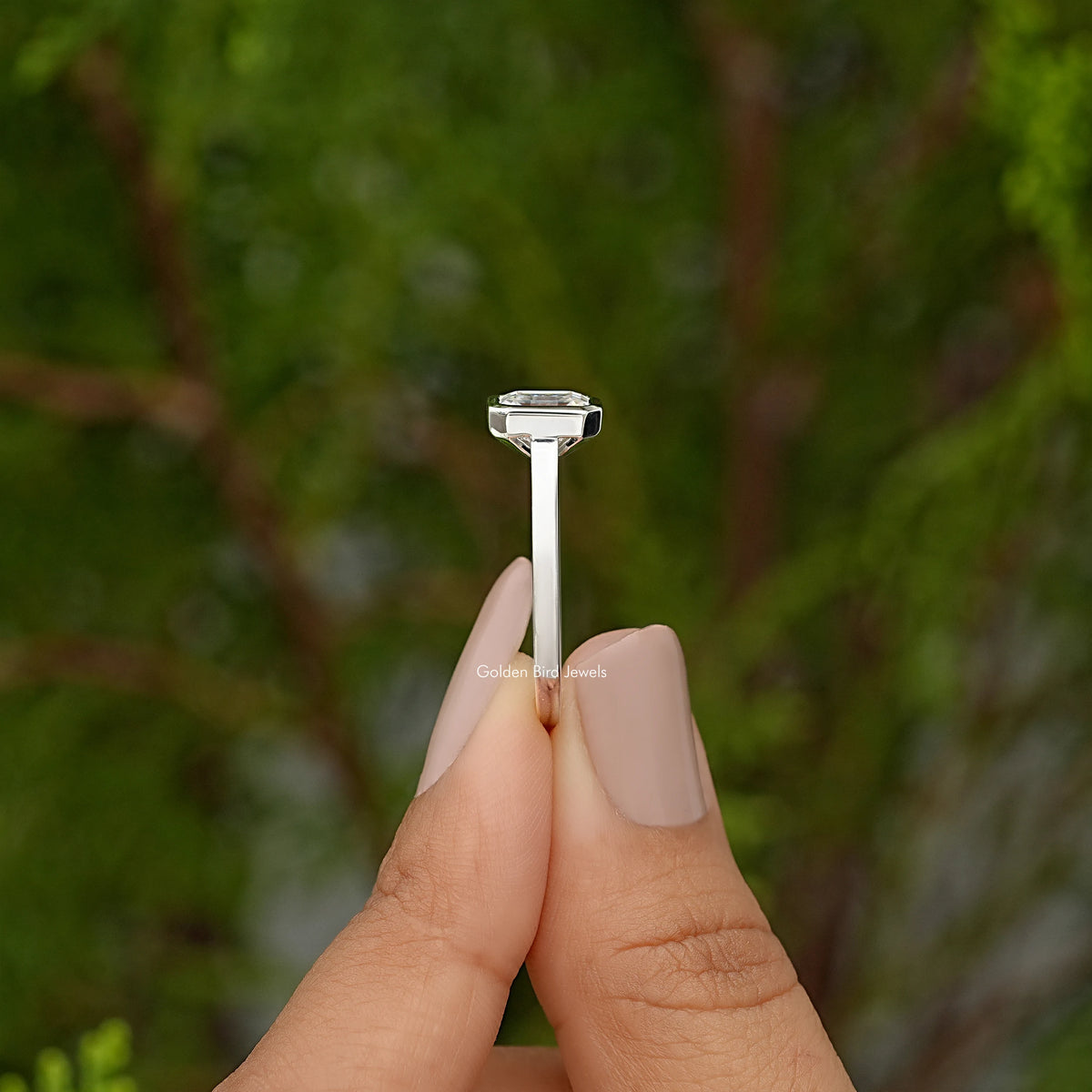 Emerald-cut moissanite bezel-set engagement ring, side view of the square stone