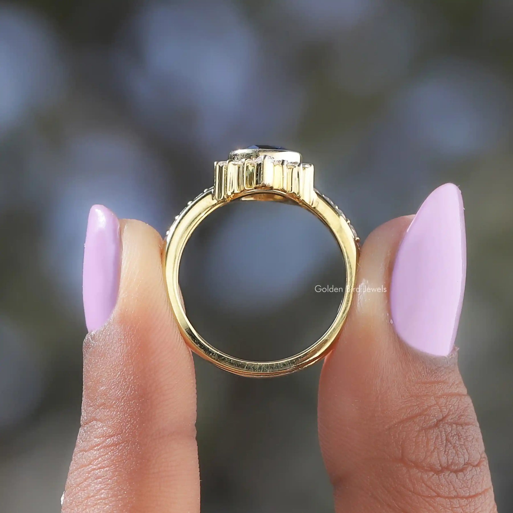 Back View of Black Pear And Round Cut Moissanite Bridal Ring In two fingers