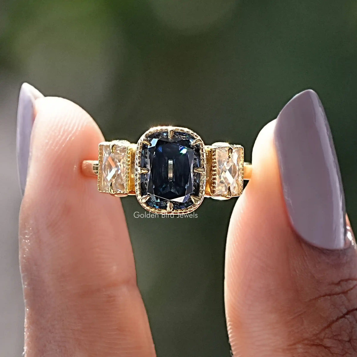 Two fingers holding the Old Mine Criss Cut Moissanite 3 Stone Ring