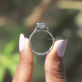 Back View of Blue Radiant Cut Moissanite Ring In two fingers