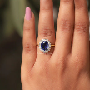 View Of Blue Oval Cut Halo Ring In a Finger