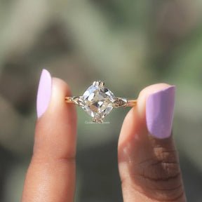 Two fingers holding the Old Mine Cushion Cut Moissanite Ring