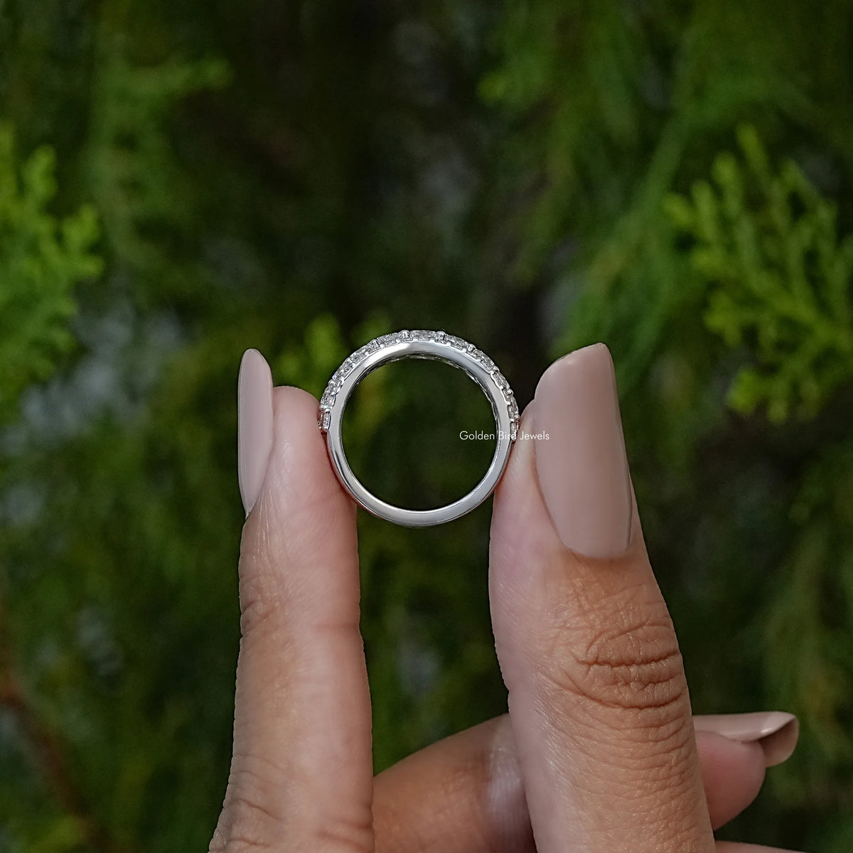 Curved eternity band ring shown from above, round clear stones on silver-tone