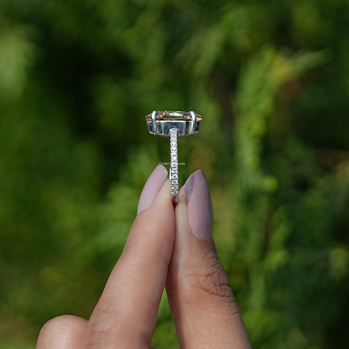 Side view of moissanite diamond ring holding on two fingers 