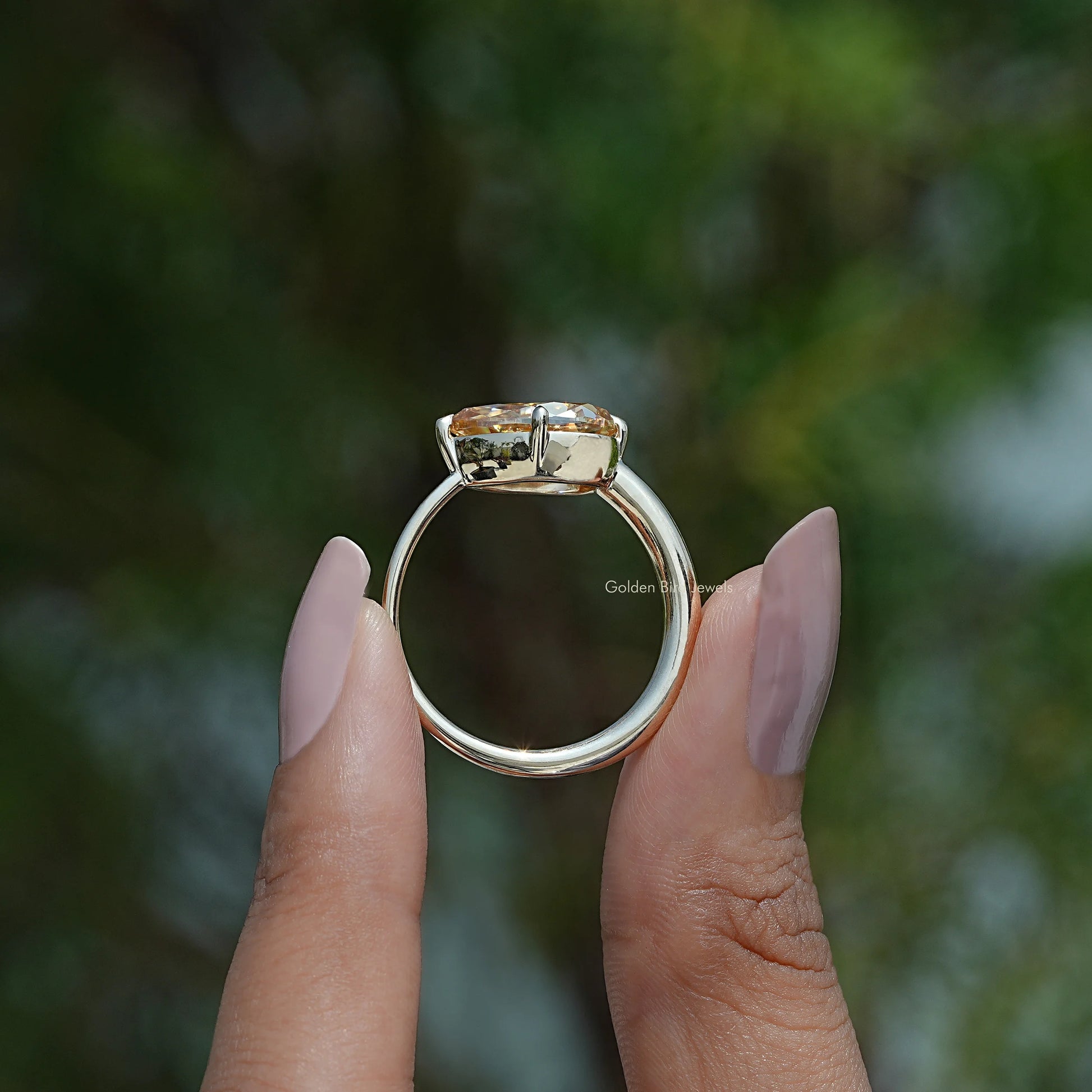Back View A  pear east west engagement ring In two fingers