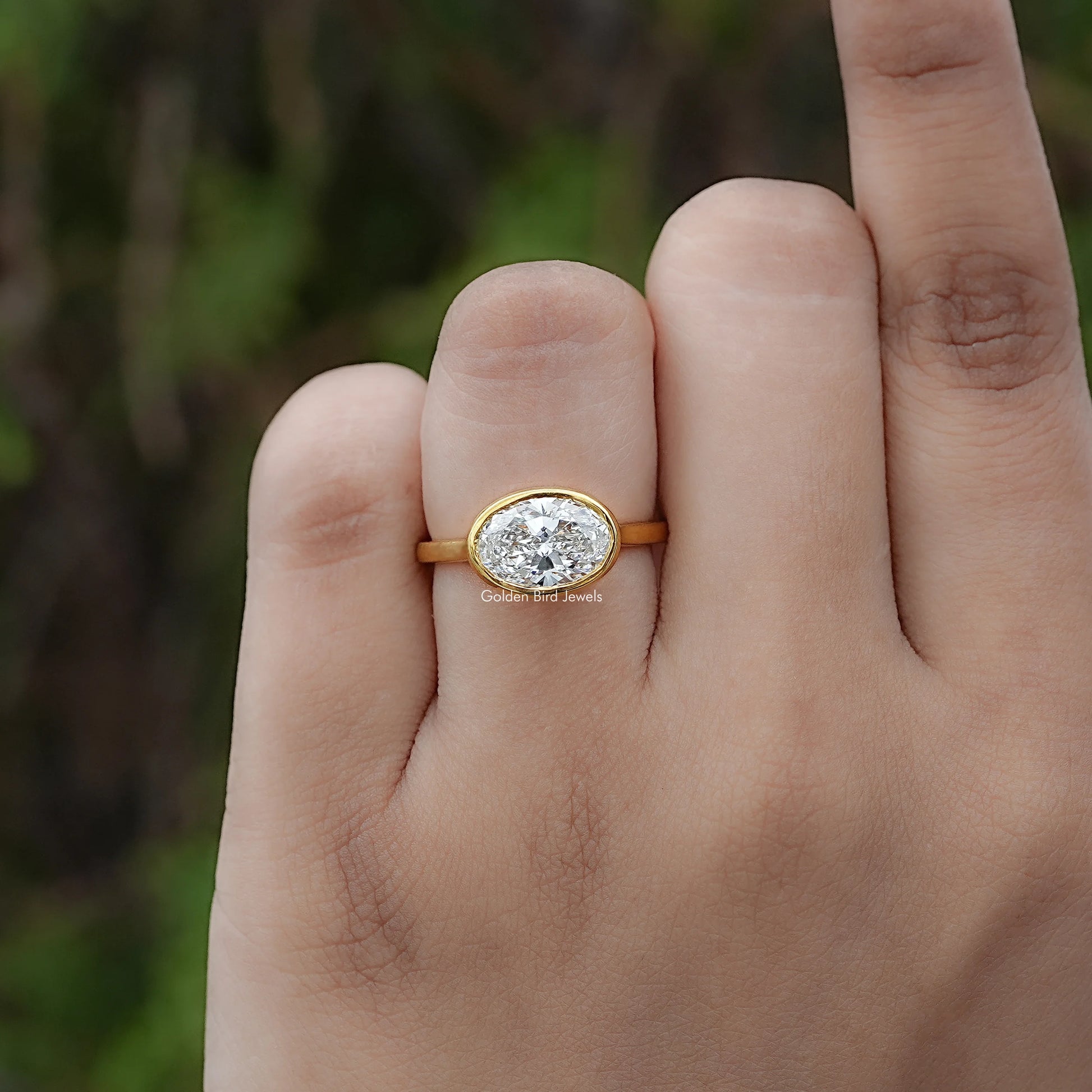 Front view of East West Oval Cut Diamond Bezel Set Ring
