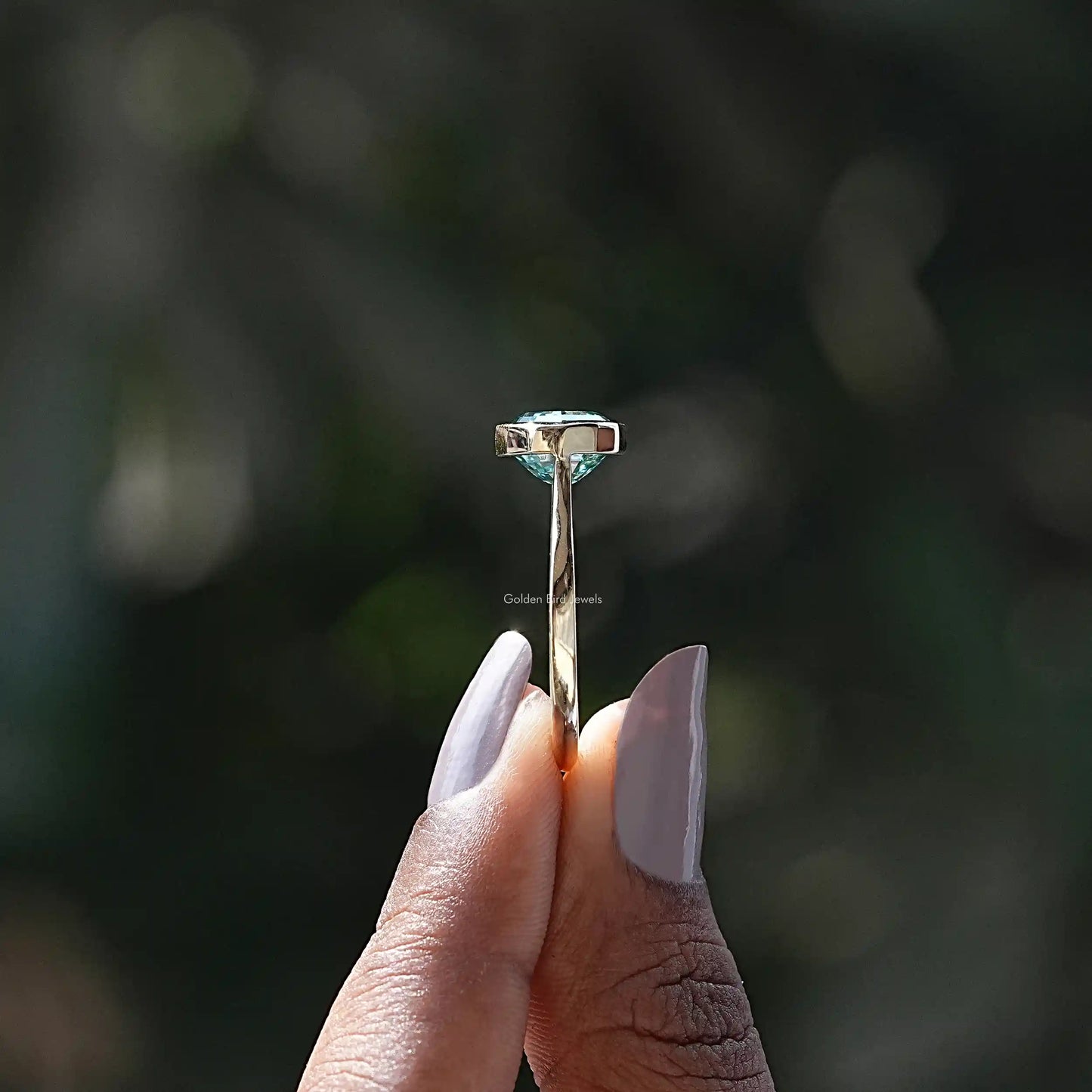 Side View of Moissanite Oval Cut East West Ring In two fingers