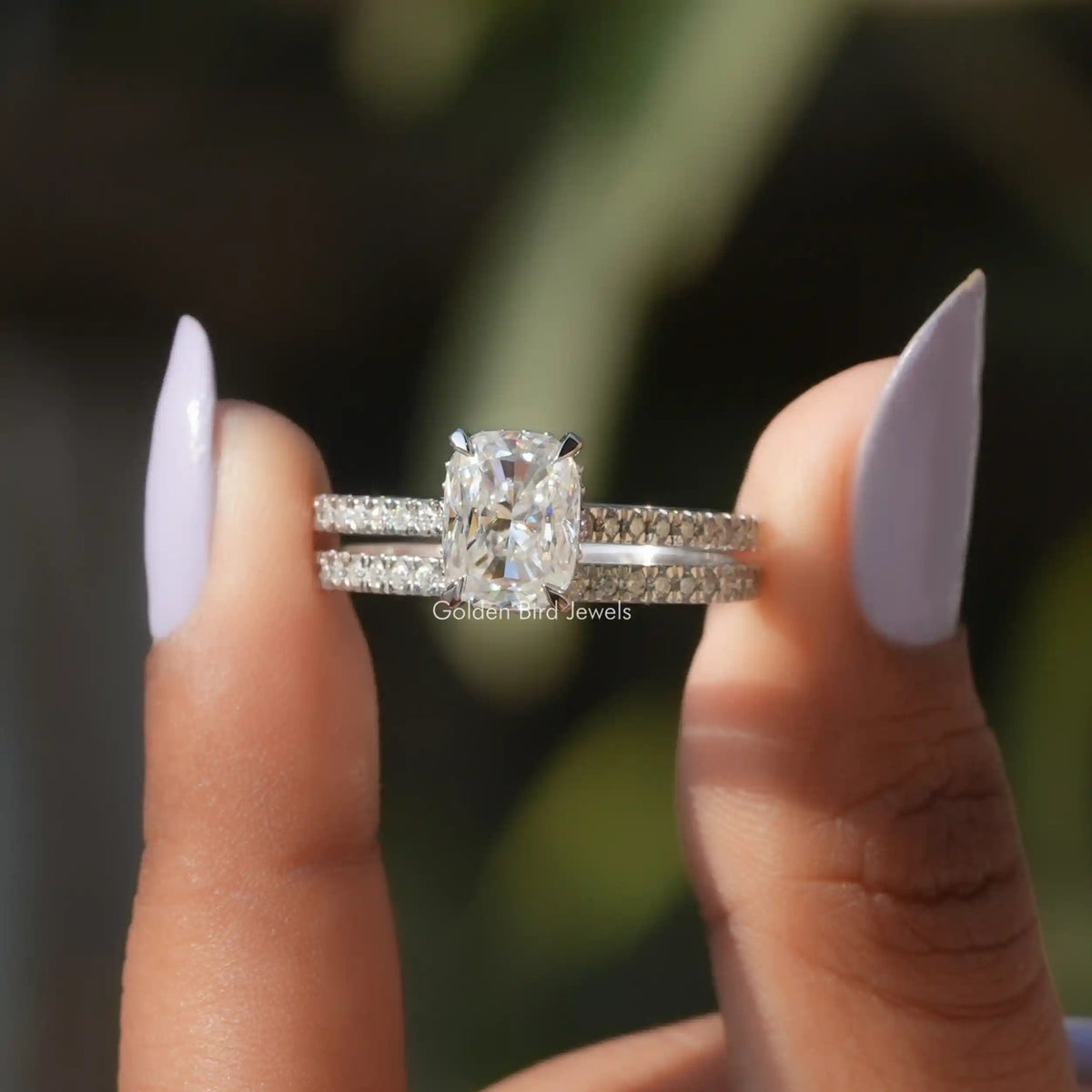 Two fingers holding the Elongated Cushion Cut Moissanite Bridal Ring Set