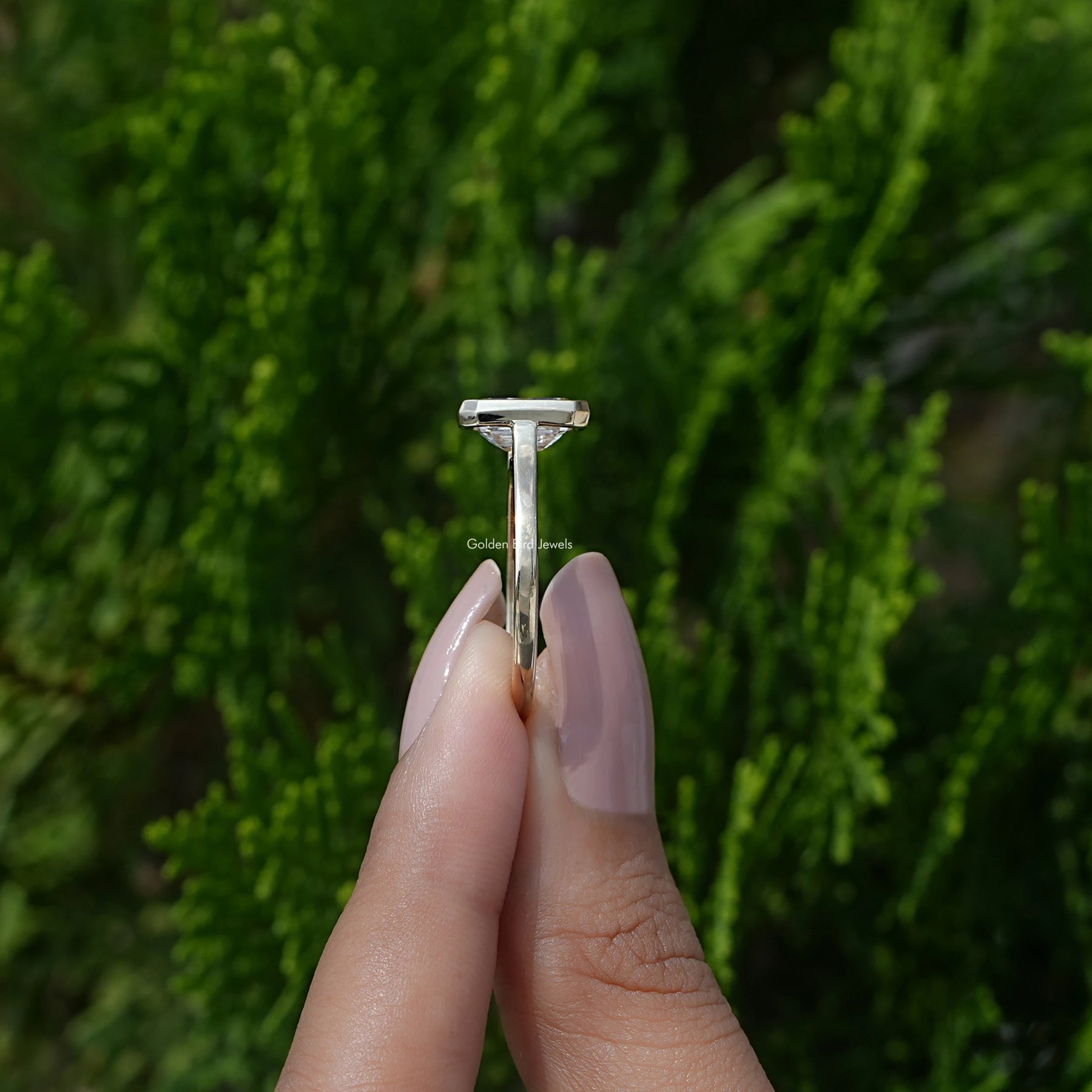 Side View of White Gold Emerald Shaped Ring in a two fingers